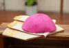 A pink ceremonial cap placed on a decorative cloth