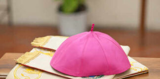 A pink ceremonial cap placed on a decorative cloth