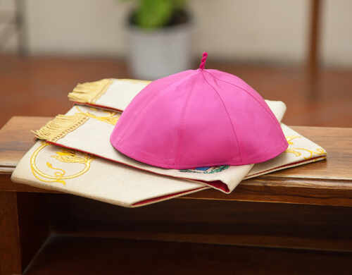 Pileolus,Purple,In,The,Church A pink ceremonial cap placed on a decorative cloth