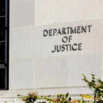 Sign on the exterior wall of the Department of Justice building