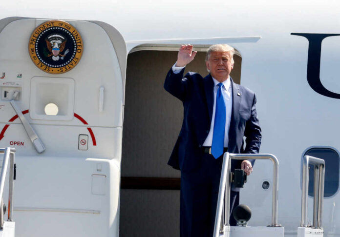 shutterstock_1836121471 A political figure waving from the steps of an aircraft