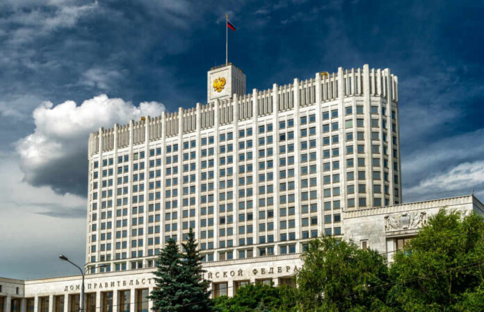 shutterstock_2167424865 Government building with a Russian flag under a cloudy sky