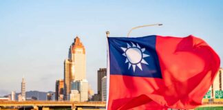 Taiwan flag waving in front of a city skyline during sunset