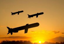 Silhouetted missiles flying against a sunset backdrop