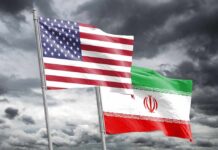 Trump’s Iran Gamble — What’s the Catch? Flags of the United States and Iran waving against a cloudy sky