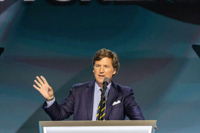 A man in a suit speaking at a podium with a microphone