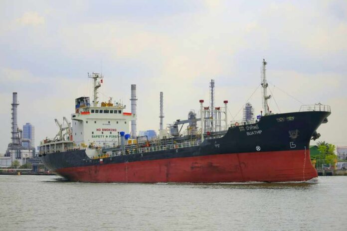 A cargo ship navigating through an industrial harbor