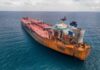 Aerial view of a large, rusty oil tanker in the ocean