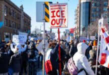 DOJ CRACKDOWN: Antifa Plot Exposed Crowd of protesters holding signs at a rally against ICE