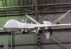 military drone with missiles suspended in a hangar