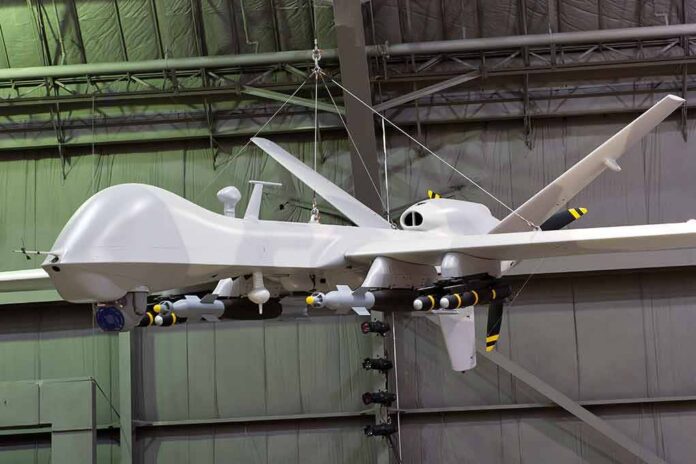 military drone with missiles suspended in a hangar