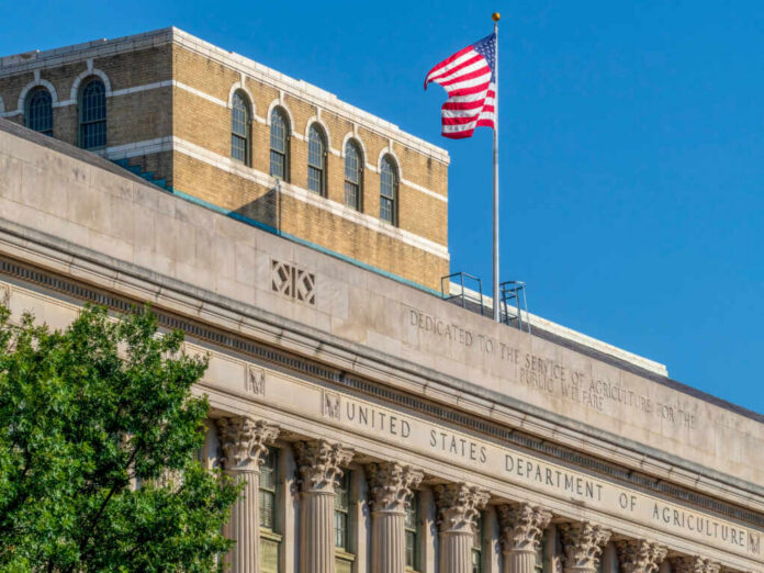 shutterstock_1212385417 Facade of the United States Department of Agriculture building with an American flag