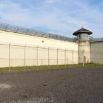 Spectacle Security Goes Next-Level Prison yard with chain-link fence and guard tower
