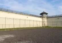 Spectacle Security Goes Next-Level Prison yard with chain-link fence and guard tower