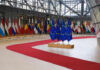 EU Biometrics Chaos — Missed Flights Mount Flags of European countries displayed in a modern hall with a red carpet