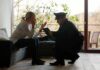 police officer speaking with distressed woman on a sofa