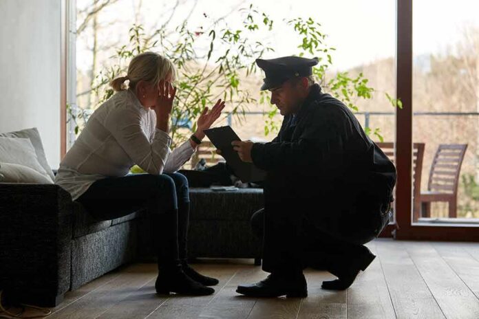 police officer speaking with distressed woman on a sofa