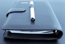 Black leather planner with pen on top