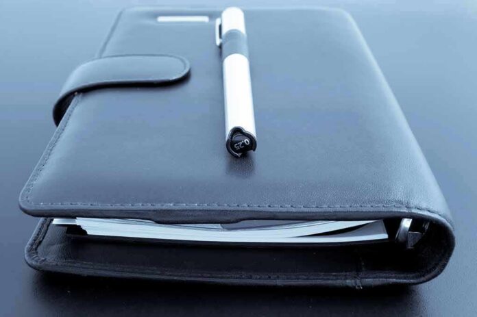 Black leather planner with pen on top
