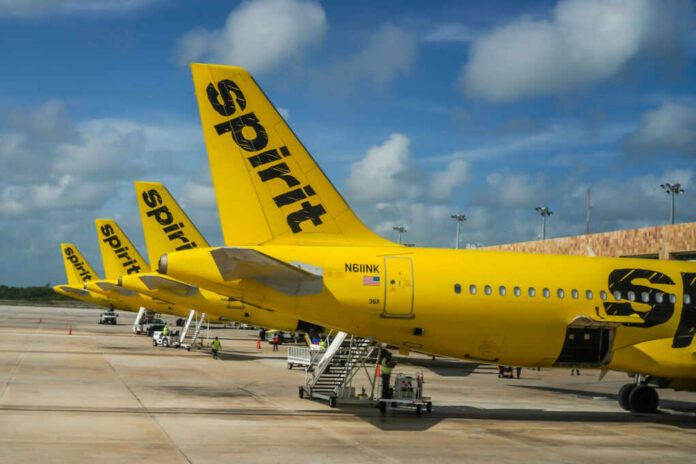shutterstock_2270944877 Multiple yellow Spirit Airlines planes parked at an airport