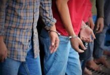 Handcuffed people standing in a line