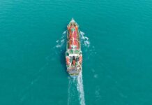 Oil Spike, Silicon Valley Panics Aerial view of a cargo ship navigating through turquoise waters