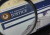Weaponized Justice? Ex-CIA Boss Fights Back Close-up view of the U.S. Department of Justice website through a magnifying glass