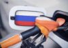 Fuel nozzle inserted into a car with a flag-themed fuel door