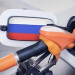 Fuel nozzle inserted into a car with a flag-themed fuel door