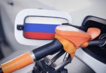 Work-From-Home Mandate Over Gas Shortage Fuel nozzle inserted into a car with a flag-themed fuel door