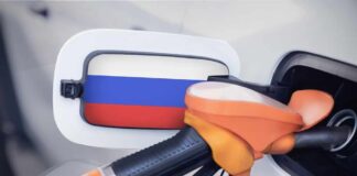 Fuel nozzle inserted into a car with a flag-themed fuel door