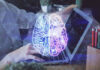 Futuristic AI brain hologram above a laptop computer.