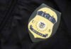 ICE officer badge on a dark uniform
