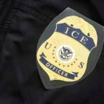 ICE officer badge on a dark uniform