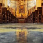 Audit Sparks Fury Over Church Funding Church interior with wooden pews facing ornate altar
