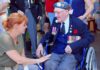 Budget Crunch Dumps Vets Parade Elderly veteran in wheelchair greeted by woman