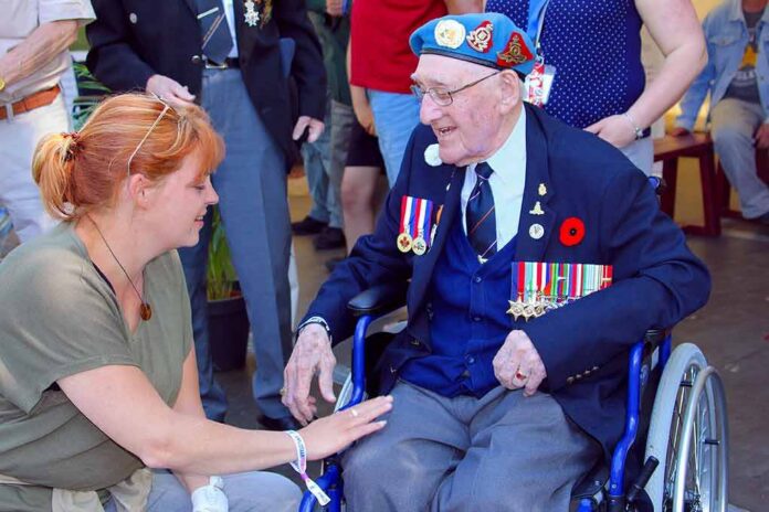 Elderly veteran in wheelchair greeted by woman