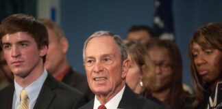 older man in suit speaking at a podium