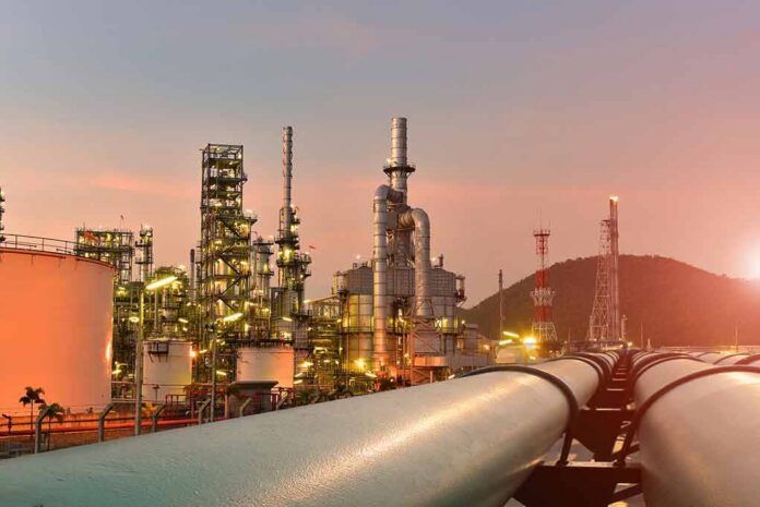 Oil refinery with pipelines at sunset