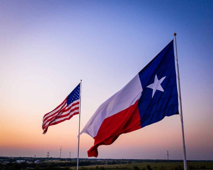 Texas and United States flags waving at sunset