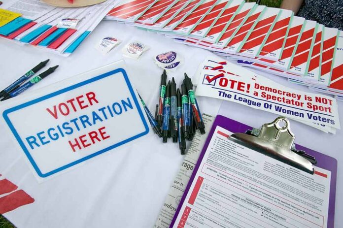 shutterstock_177445370 Voter registration table with forms, pens, and informational materials