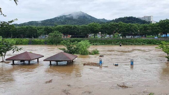 shutterstock_1786013174 Rising floodwaters submerge riverside park shelters