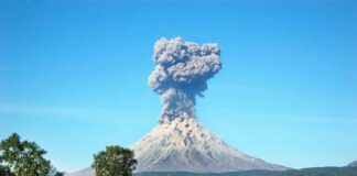 Volcano erupting with a towering ash plume