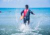 Hero Dive Ends In Horror lifeguard wading into ocean with rescue buoy