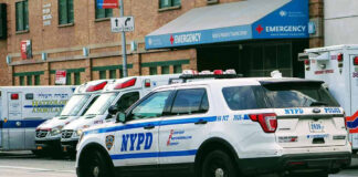 Police car and ambulances outside emergency room entrance.