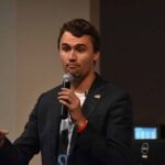 Professor’s X Tirade Sparks CMU Probe man speaking into a microphone on stage