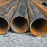 Rusty metal pipes laid on gravel