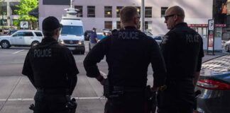 Police officers stand on a city street