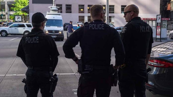 Police officers stand on a city street