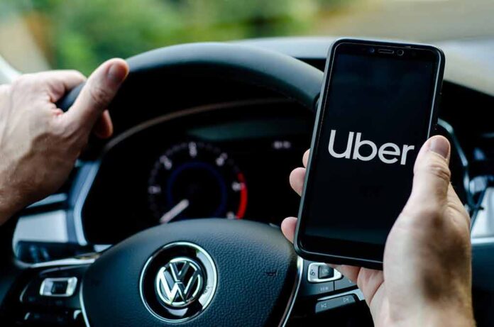 Driver holding smartphone with Uber app inside Volkswagen